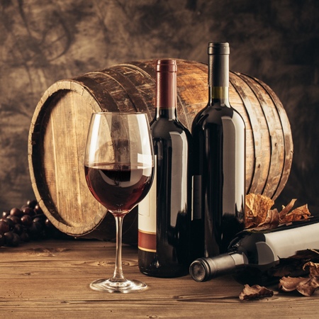 Weinfass mit erlesenen Weinsorten in Flaschen und Glas